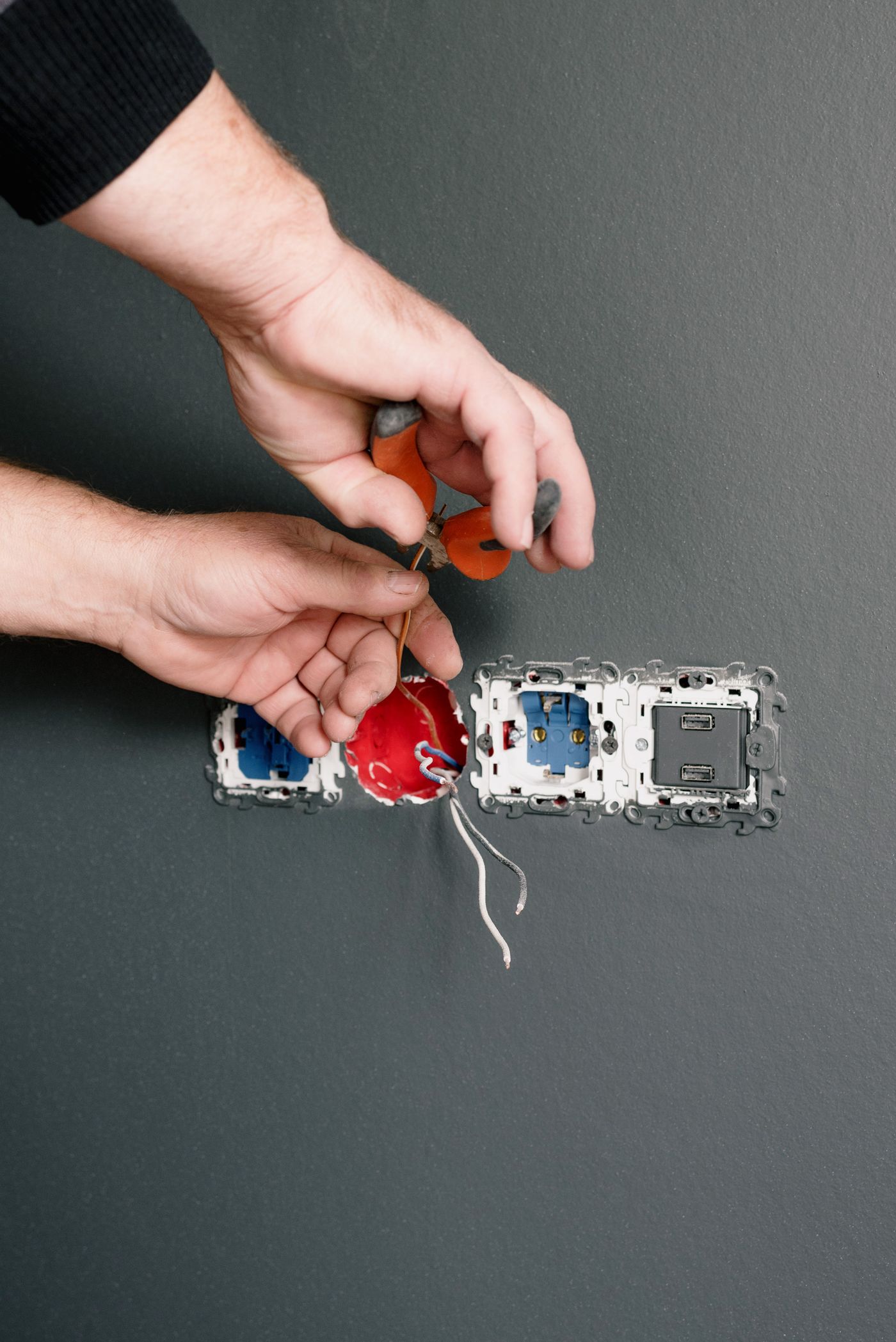 Eletricista instalando uma tomada na parede de um apartamento